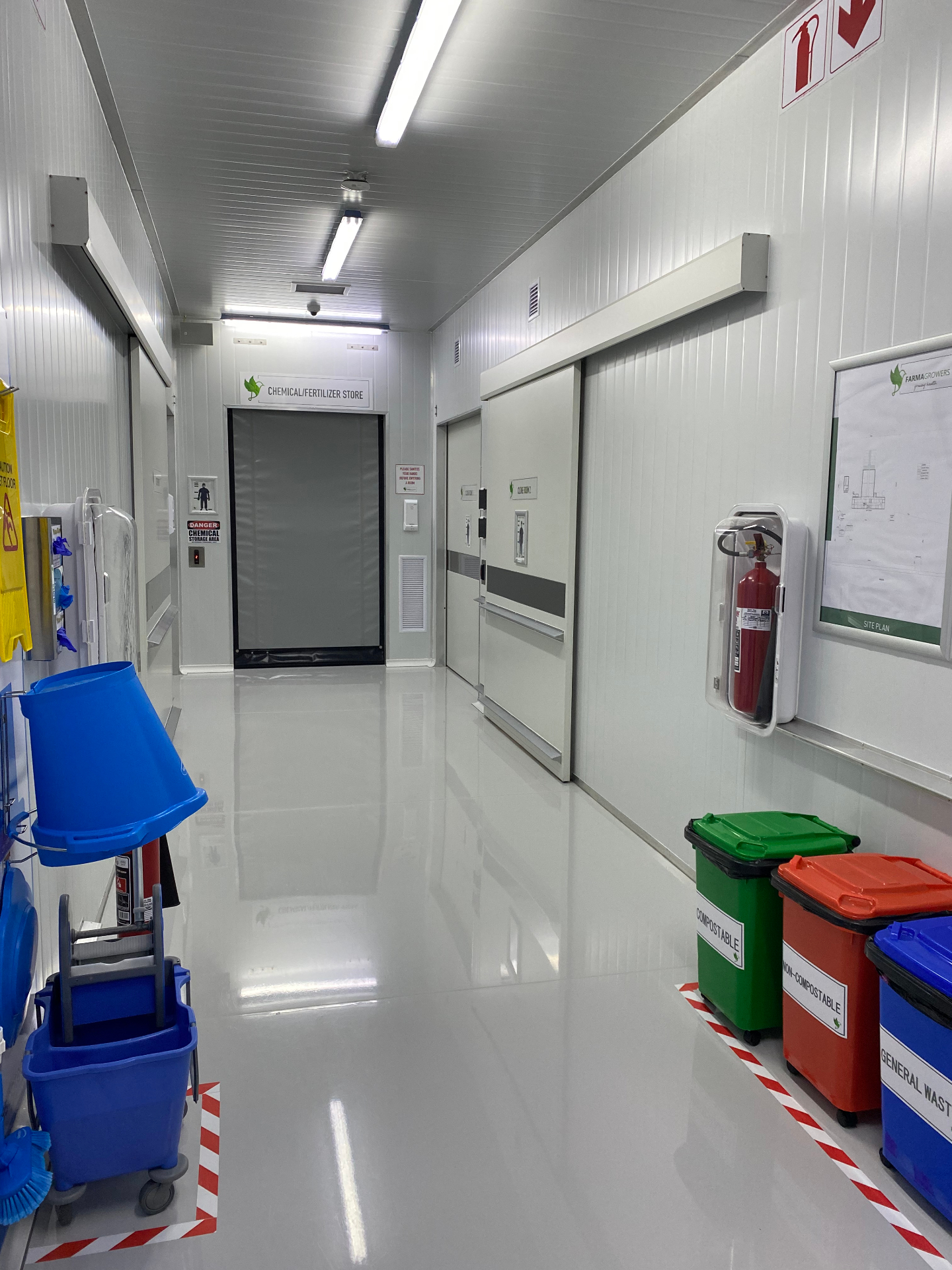 Corridor to chemical/fertilizer store with color-coded waste bins